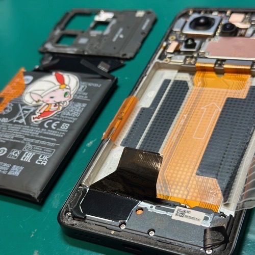 専用ツールで膨張バッテリーを安全に取り外し中