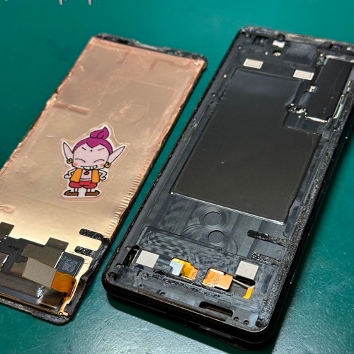 破損し縦線が入ったXperia 5 IIの古い画面を本体フレームから剥がし、取り外している作業風景。